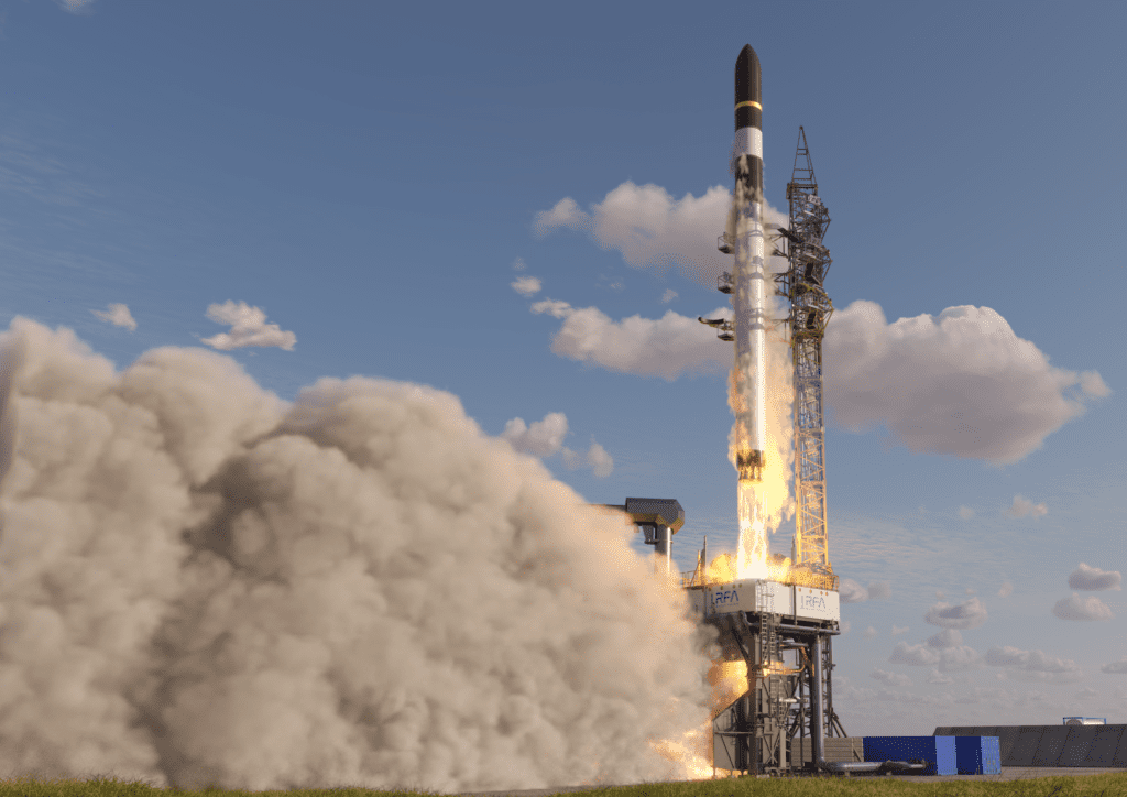 The rocket RFA ONE is lifting off the launch pad. On the left a big smoke plume is visible.